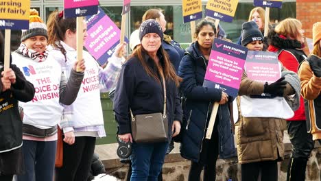 Frustrated-overworked-NHS-staff-union-at-Whiston-hospital-demonstration-on-the-picket-line-with-banners-and-flags-for-fair-pay