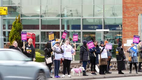 Überlastete-NHS-Arbeiter-Im-Whiston-Hospital-In-St.-Helens,-Merseyside,-Protestieren-An-Der-Streikpostenlinie-Mit-Transparenten-Und-Fahnen,-Die-Eine-Faire-Bezahlung-Fordern