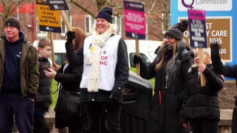 Huelga-De-Personal-Del-Nhs-Con-Exceso-De-Trabajo-En-La-Línea-De-Piquete-Con-Pancartas-Y-Banderas-En-El-Hospital-De-St-Helens-En-Protesta-Exigiendo-Un-Salario-Justo