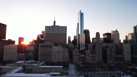 Aerial-shot-of-Chicago-city-at-sunrise,-winter-snowy-landscape-with-buildings-and-skyscrapers