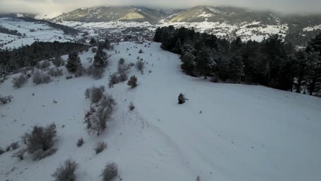 Winter-landscape-with-pine-trees-and-hills-covered-in-snow-near-ski-resort-of-touristic-village-in-Albania