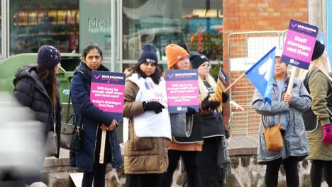 Underfunded-and-overworked-NHS-workers-at-Whiston-hospital-in-St-Helens,-Merseyside-protest-with-banners-and-flags-demanding-fair-pay