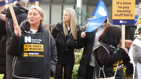 Overworked-NHS-workers-protest-on-the-picket-line-with-banners-and-flags-demanding-fair-pay