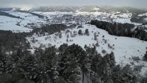 Mountains-covered-in-snow-and-black-pine-forests-surrounding-touristic-village-of-Voskopoja-in-Albania