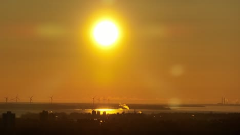Nahaufnahme-Eines-Sonnenuntergangs-Mit-Windmühlen-Im-Hintergrund,-Luftaufnahme