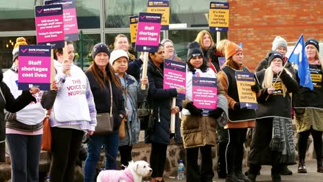 Überlastete-NHS-Mitarbeiter-Im-Whiston-Hospital-Protestieren-An-Der-Streikpostenlinie-Mit-Transparenten-Und-Fahnen-Für-Faire-Lohnbedingungen