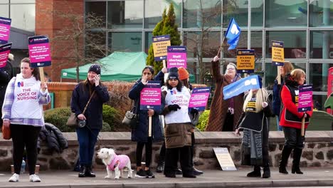 Überlastete-NHS-Arbeiter-Protestieren-Vor-Dem-Krankenhaus-In-St.-Helens-An-Der-Streikpostenkette-Mit-Transparenten-Und-Fahnen,-Die-Eine-Faire-Bezahlung-Fordern