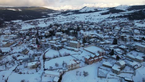 Pueblo-De-Montaña-En-Invierno-Con-Hermosas-Casas-De-Piedra-Y-Casas-De-Huéspedes-Cubiertas-De-Nieve,-Albania