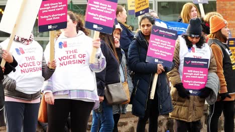 Frustrated-overworked-NHS-staff-union-at-Whiston-hospital-demonstration-on-the-picket-line-with-slogan-banners-and-flags-for-fair-pay