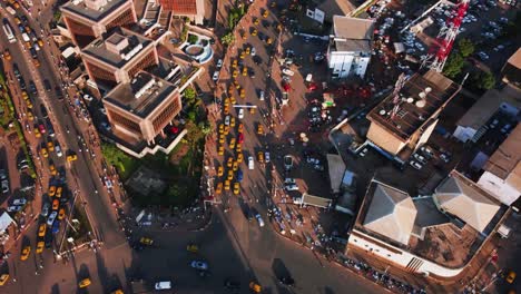 Aerial-view-overlooking-yellow-taxis-and-traffic-on-the-streets-of-Yaounde,-Cameroon