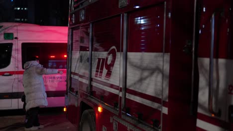 Korean-People-walking-by-Firetruck-and-Ambulance-with-Flashing-Emergency-Lights