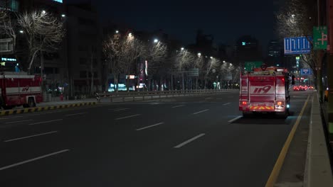 Camiones-De-Bomberos-Conduciendo-Por-La-Amplia-Carretera-De-La-Ciudad-De-Seúl-Con-Luces-Intermitentes-Rojas-De-Emergencia