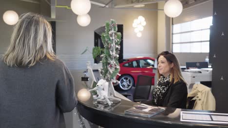 A-blonde-customer-walks-into-a-car-dealership-and-arrives-at-the-counter