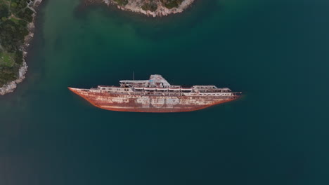 Aerial:-Top-down-shot-of-half-sunken-shipwreck-in-Elefsina,-Greece-during-sunset