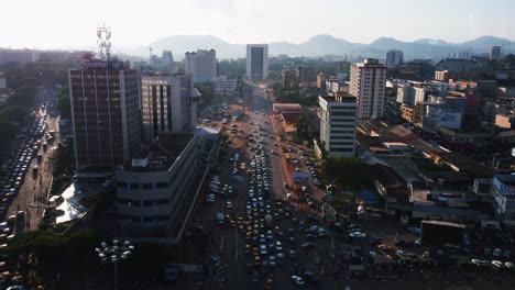 Aerial-Flyover-over-traffic-on-the-N2-street-in-downtown-Yaounde,-sunny-Cameroon