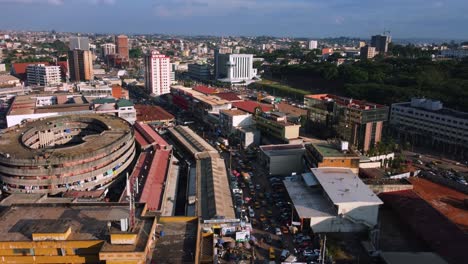 Yaounde-city-shopping-streets-packed-with-people-and-cars,-sunny-day-in-Cameroon,-Africa---Ascending,-drone-shot