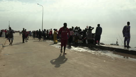 People-walking-around-others-waiting-for-the-fish-on-the-main-wall-of-the-fishing-port-of-Bandim