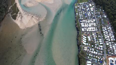 Aerial-top-down-holiday-park-river-reveal-to-sunrise,-Lake-Conjola-Australia
