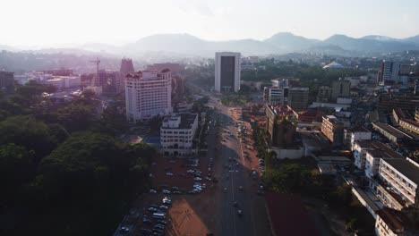 Aerial-view-rising-over-the-Bd-du-20-mai-street-in-downtown-Yaounde,-sunny-Cameroon