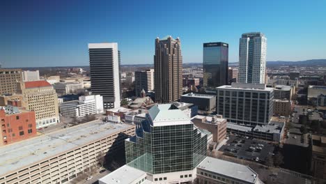 Beautiful-aerial-view-of-downtown-cityscape-of-Birmingham,-Alabama-pulling-away-to-reveal-skyscrapers-and-skyline