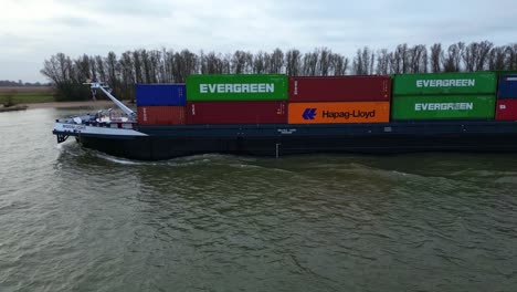 Aerial-Dolly-Back-Parallax-Shot-Of-Moonlight-Inland-Motor-Freighter-Sailing-Along-Beneden-Merwede-Carrying-Intermodal-Containers