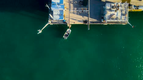 Aerial-view-of-a-small-boat-next-to-Scripps-pier-in-La-Jolla