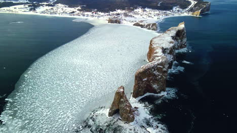 Luftaufnahme-Des-Percé-Felsens-Im-Winter-Mit-Eis-Auf-Dem-Ozean