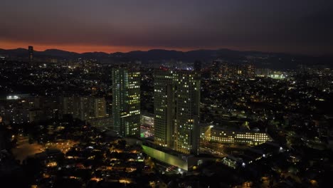 Tracking-aerial-view-of-the-Arcos-Bosques-skyscraper-complex,-dramatic-dawn-in-Mexico-city