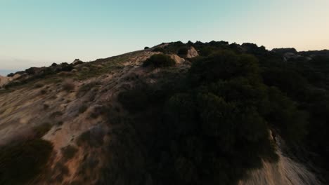 Eine-Schnelle-FPV-Drohne-Schoss-Während-Des-Sonnenuntergangs-über-Die-Hügelige-Landschaft-Von-Calanchi-Di-Aliano-In-Italien