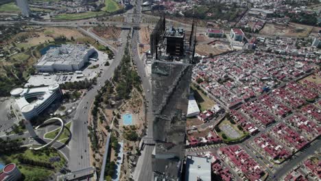 Top-view-of-the-Tower-JV-in-Puebla,-Mexico-and-it-has-other-buildings-near-like-a-university-and-museum,-there-is-also-the-main-avenue-and-the-houses-that-surround-the-tower