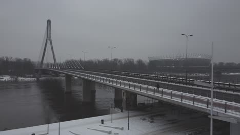 Drone-video-of-and-swietokrzsyki-bridge,-warsaw-above-Vistula-river-on-a-snowy-day--3
