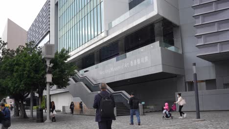Museo-De-Arte-De-Hong-Kong,-Edificio-Moderno-Con-Escaleras-Y-Gente-Caminando-En-La-Calle