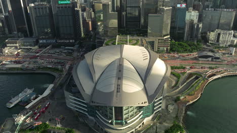 Aerial-tilt-up-shot-of-famous-modern-Exhibition-Centre-in-Wan-Chai-with-skyline-of-Hong-Kong-City