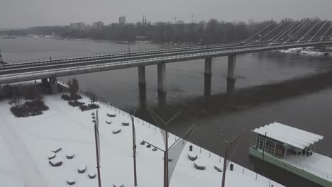 Drone-video-of-and-swietokrzsyki-bridge,-warsaw-above-Vistula-river-on-a-snowy-day--2