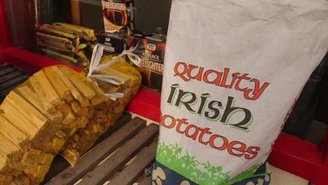 Static-shot-outside-a-typical-irish-shop-with-a-bag-of-irish-potatoes,-wood-and-firelighters-for-the-chimney