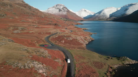 Van-driving-down-lakeside-track-with-mountains-in-distance-in-winter-at-Wastwater-Lake-District-UK