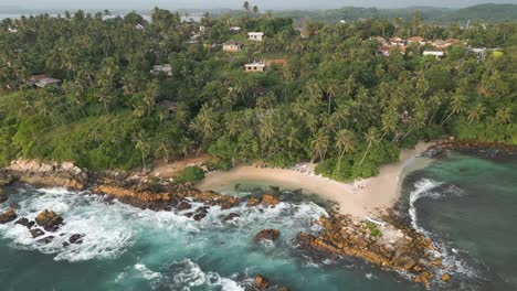 Mirissa-Secret-Beach,-Sri-Lanka---Aerial-drone-footage-zooming-out-revealing-the-local-town