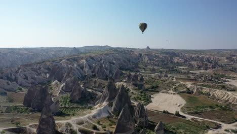 Epic-cinematic-drone-shot-following-a-hot-air-balloon-floating-over-Cappadocia,-Turkey