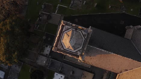 Aerial-cenital-rotating-shot,-top-view-of-main-church's-tower-in-Gort,-Ireland-on-sunset