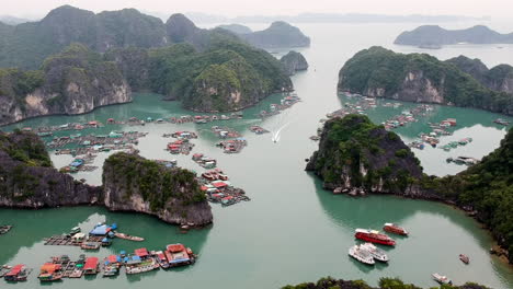 Halong-Bay-Vietnam-Barcos-De-Pesca-Y-Fisher-Viallage-Drone-Video-Sobre-El-Mar-Y-La-Montaña-De-Pilares-De-Piedra-Caliza-Verde