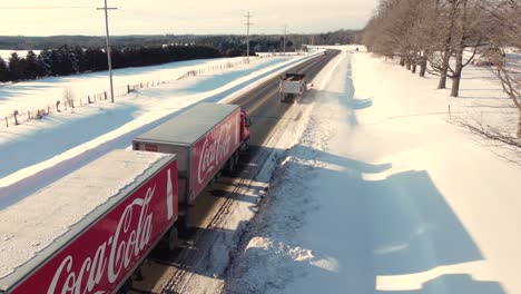 Aerial-view-of-a-Coca-Cola-truck-on-the-highway-during-the-winter-holiday-season