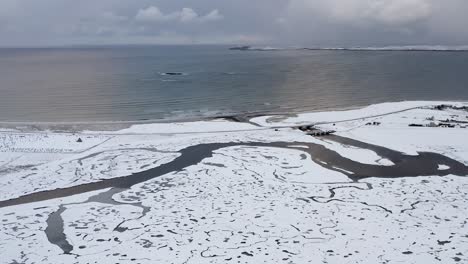 Dynamische-Drohnenaufnahme-Des-Schneebedeckten-Flusses-Gres-Mit-Gres-Strand-Und-Punkt-Im-Hintergrund-Auf-Den-äußeren-Hebriden-Schottlands