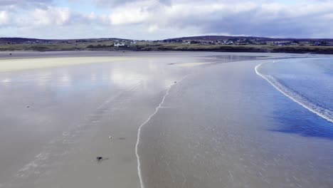 Panning-drone-shot-of-the-waves-at-Gress-beach-at-low-tide-on-the-Outer-Hebrides-of-Scotland