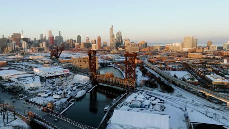 Aerial-view-around-a-train-driving-through-the-Pennsylvania-Railroad-Bridge-466,-winter-sunset-in-Chicago,-USA