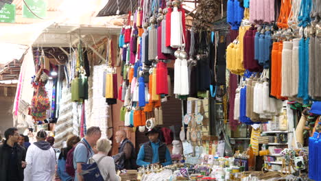 Toma-Panorámica-Que-Revela-La-Escena-Típica-De-Los-Turistas-Que-Compran-Textiles-En-Un-Puesto-En-La-Calle-En-Marruecos-Durante-El-Día