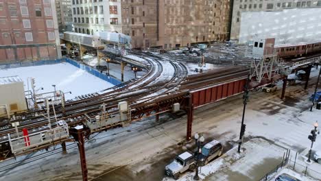 Fixed-drone-shot-of-trains-in-middle-of-buildings-in-wintry-downtown-Chicago,-USA