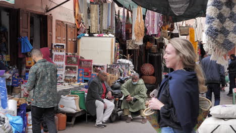 Smiling-blonde-female-sightseeing-and-exploring-Median-bazaar-alley,-Marrakesh,-Morocco