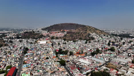 Aerial-overview-of-a-shantytown,-in-sunny-Iztapalapa,-Mexico---reverse,-drone-shot