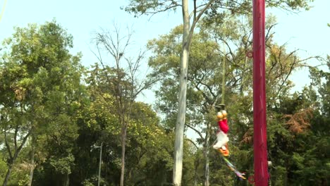 Zoom-out,-Papantla-flyers-flying-around-the-pole