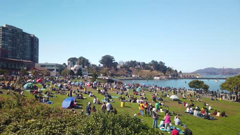 Toma-Panorámica-De-Cardán-De-La-Multitud-Reunida-En-El-Césped-En-El-Paseo-Marítimo-Para-La-Semana-De-La-Flota-En-San-Francisco,-California